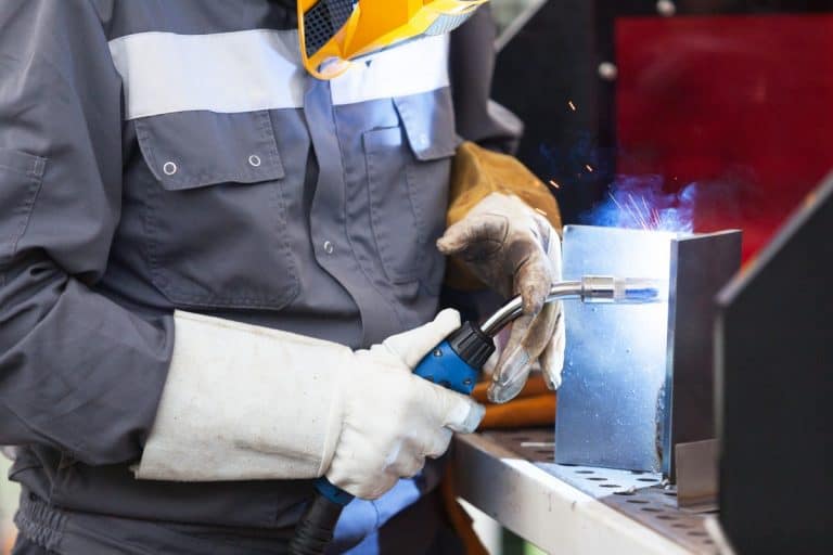 Welder working with gloves on.